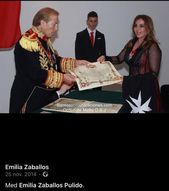 Screenshot of a Facebook post: a man in a gold-embroidered uniform hands a diploma to a woman in a black mantle with a white eight-pointed cross.