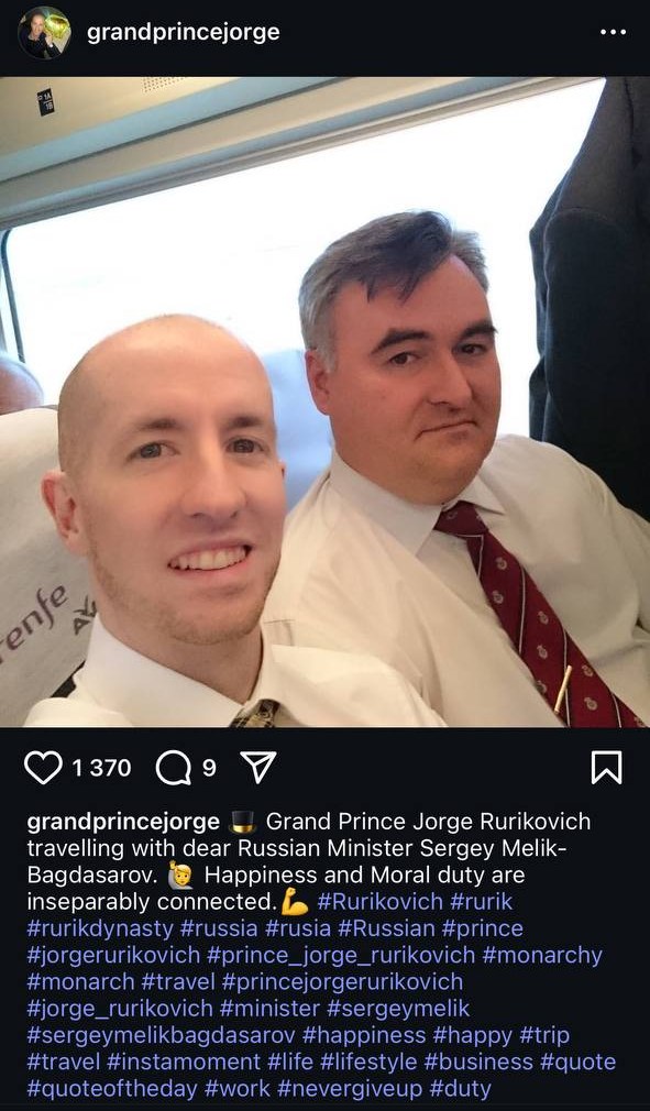 Screenshot of an Instagram post: two men in white shirts take a selfie on a train.